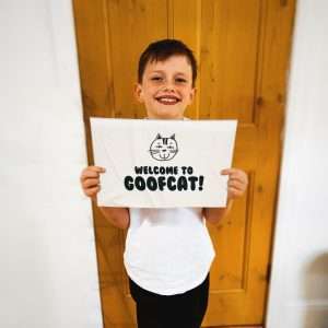 Goofcat Greetings - Our Journey goofcat alfie the brand logo designer holding a sign saying welcome to goofcat